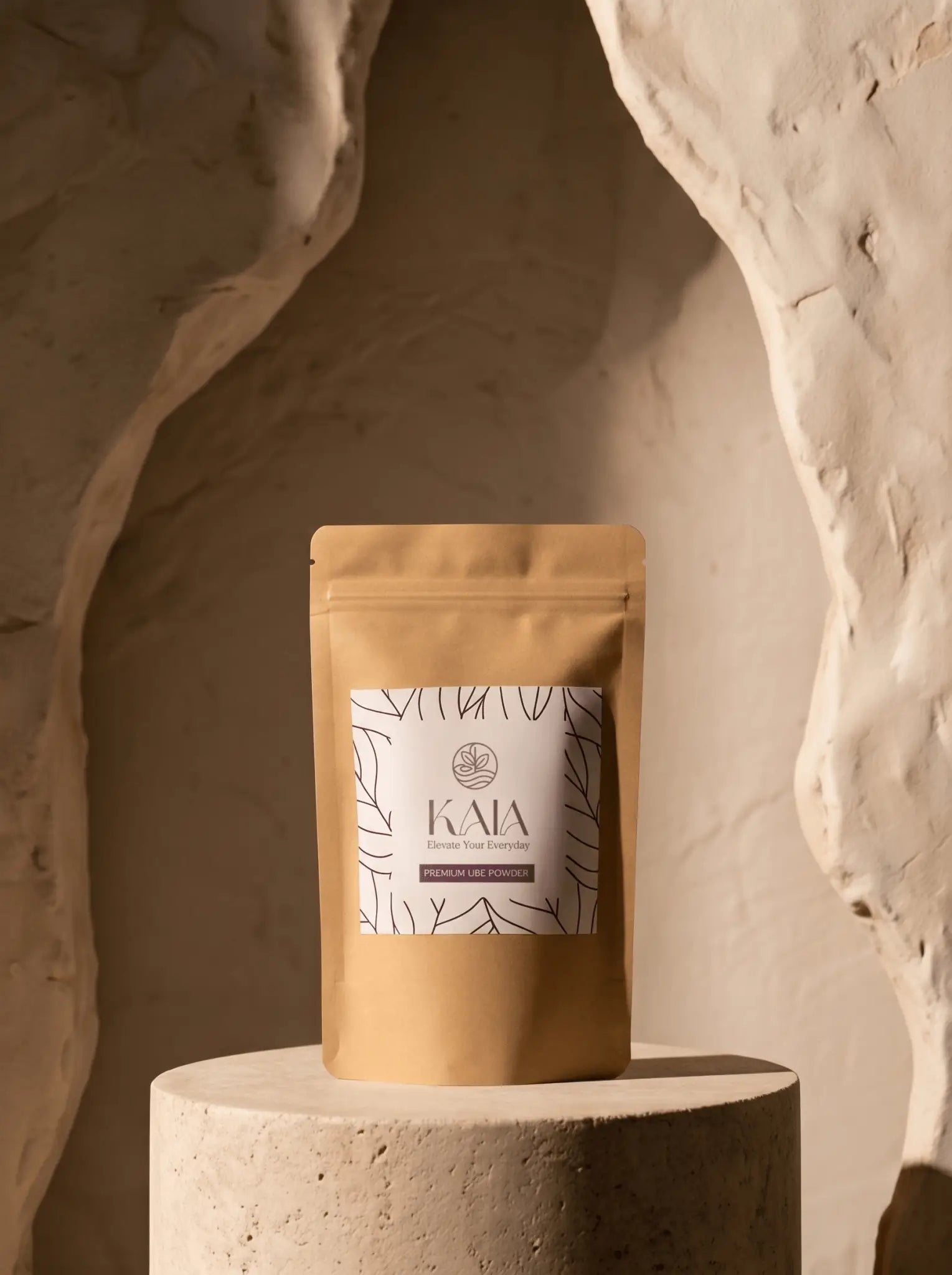 KAIA Origin premium ube powder 100g pouch in editorial sculpted setting, Belgian freeze-dried purple yam premium packaging
